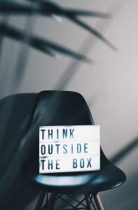 think outside the box written on light up board.