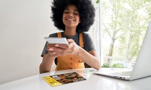 lady holding smart phone scanning a QR code on direct mail flyer