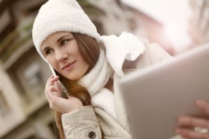 Woman in white hat using smartphone