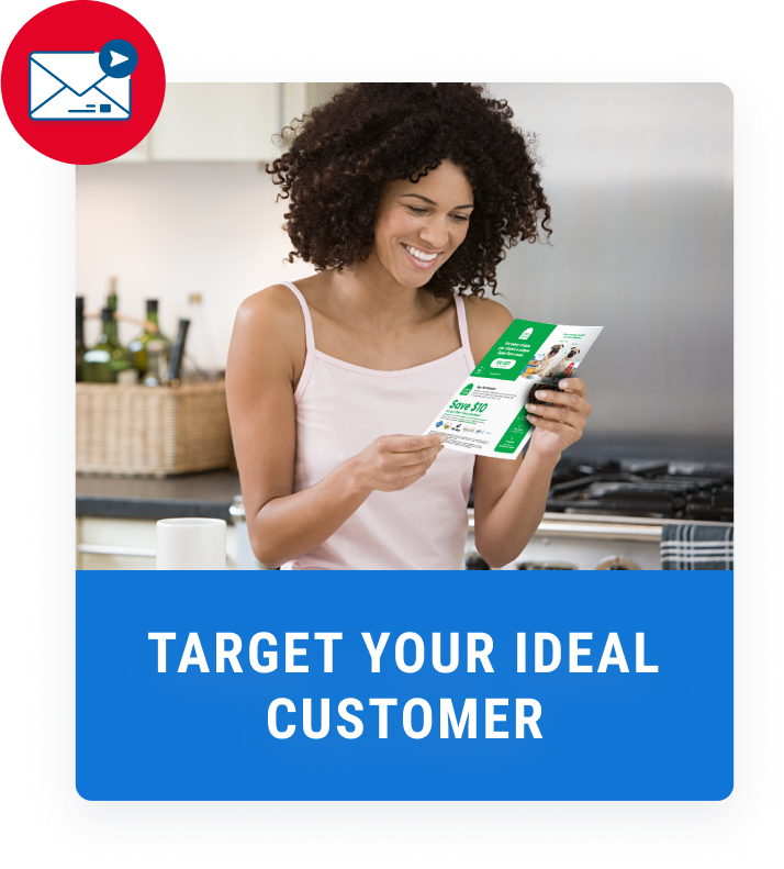 woman in kitchen smiling while reading a green coupon flyer
